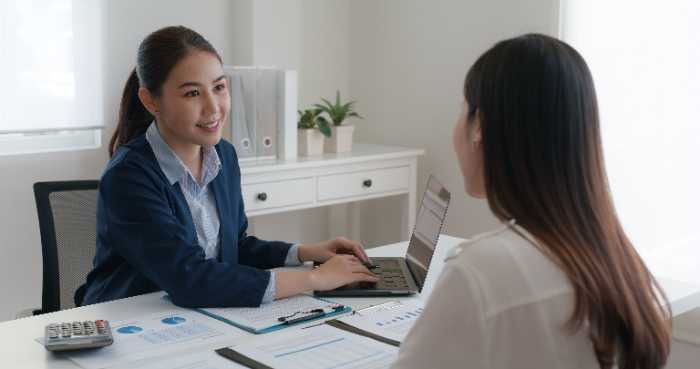 Two people looking at a computer Description automatically generated with low confidence