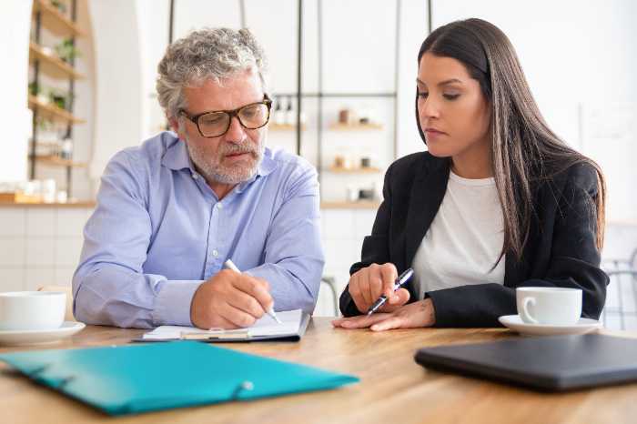 Two people looking at a tablet Description automatically generated with medium confidence